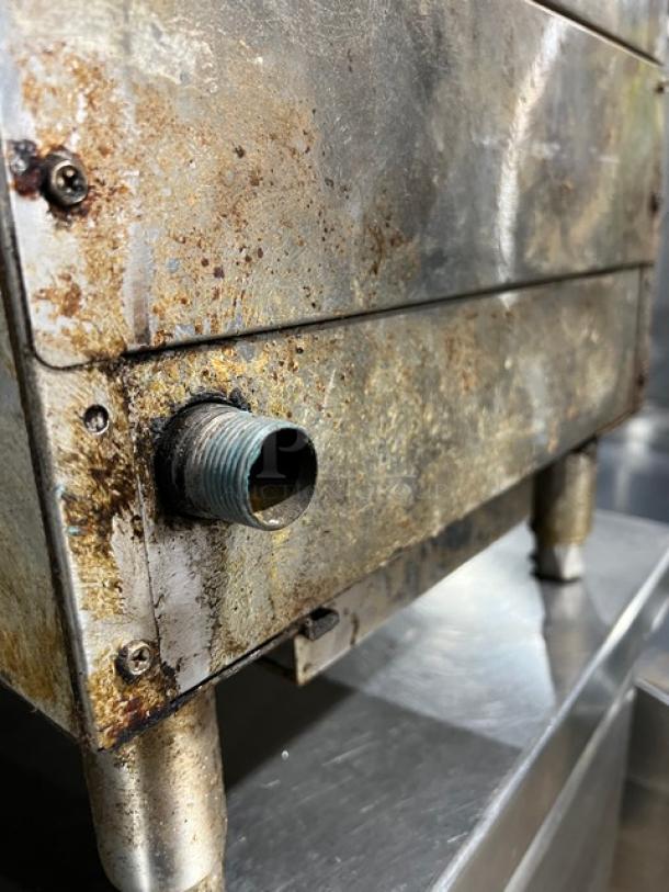 CPG Natural Gas 15" Countertop Char Broiler Grill, metal exterior, visible rust and wear, mounted on short legs.