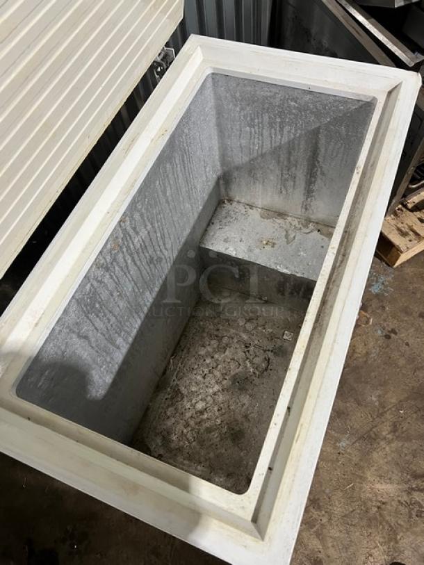 GE white deep chest freezer, model FCM7SUBWW. Interior shows wear. Serial GS101196, 115V, 1 phase.