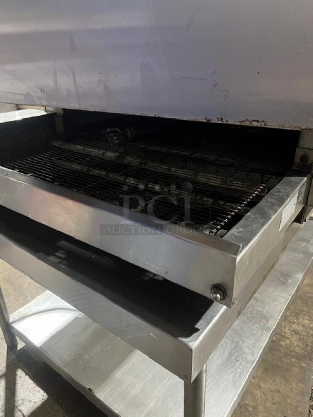 Electric Micro Drive stainless steel conveyor pizza oven on a stand with casters. Perfect for efficient baking.