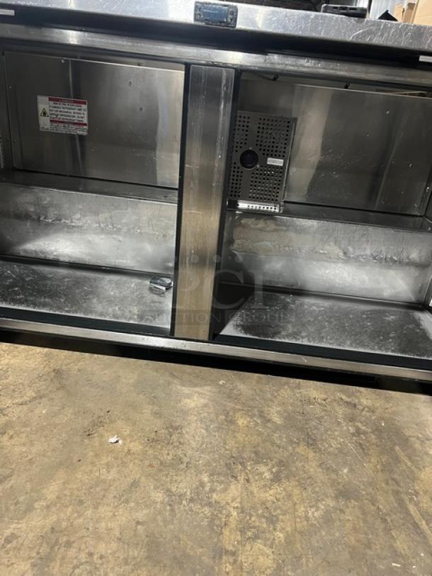 True TUC60 stainless steel refrigerated work top cooler, 115V, 1 phase, featuring dual doors and casters, model tag visible.