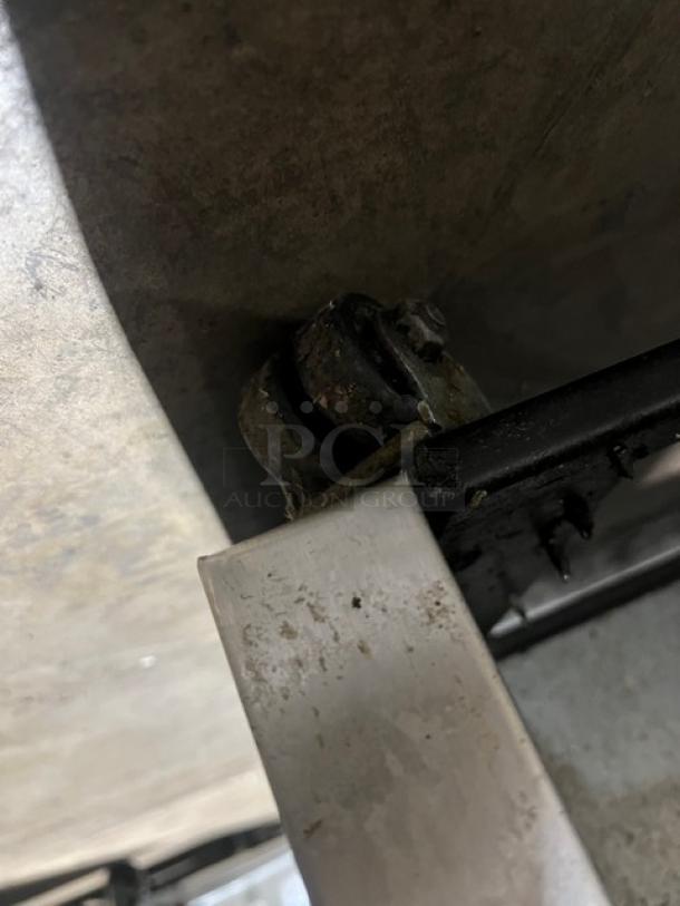 True TUC60 stainless steel refrigerated work top cooler corner detail, shows caster wheel. Model TUC60, serial 10343969.