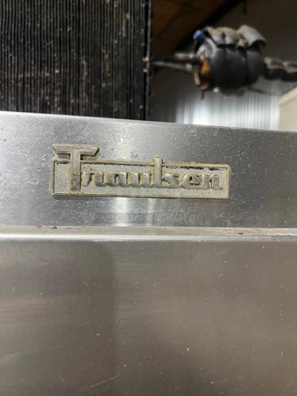 Traulsen 6 split door reach-in cooler with built-in pan racks on casters, 115V 1 phase, visible Traulsen logo.