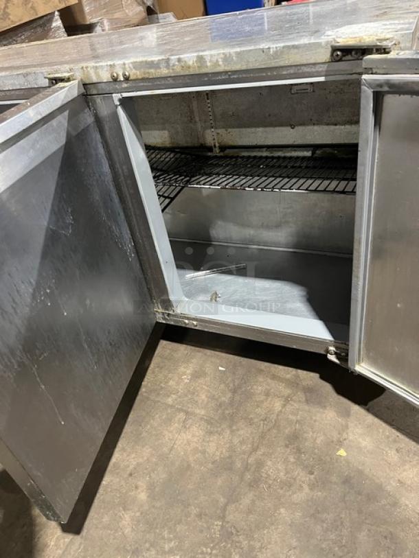 Continental 3-door under-counter lowboy cooler, features racks, on casters, 115V 1Phase, visible wear, spacious interior.