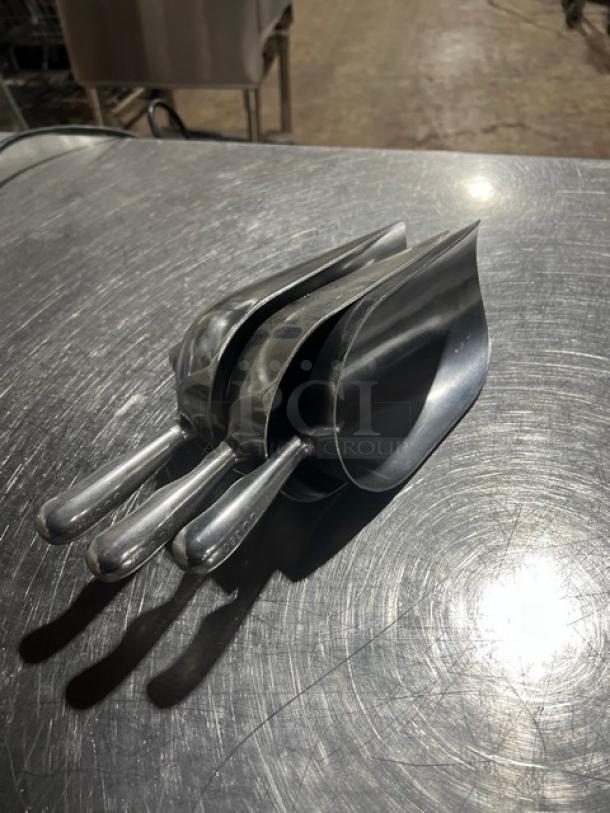 New Winco Aluminum Ice Scoops, Model AS38, set of three, polished finish, in new condition, on metal table.
