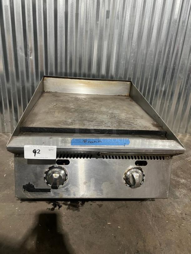 Starmax 24" natural gas flat griddle, thermostatic control, on legs, stainless steel, used condition, visible dials and markings.