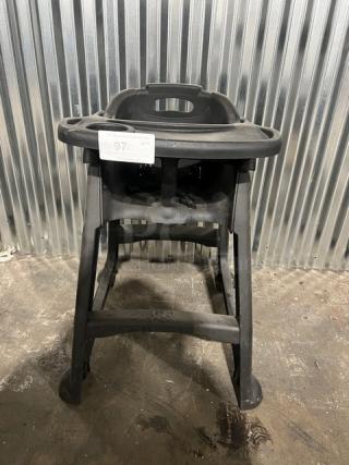 Commercial black restaurant high chair with tray, durable plastic, light wear, identification tag showing "97 QTY".