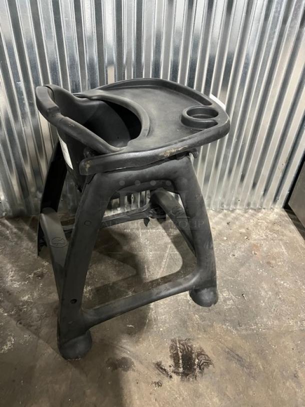 Commercial black restaurant high chair with tray, durable plastic, cup holder, used condition, ideal for dining establishments.