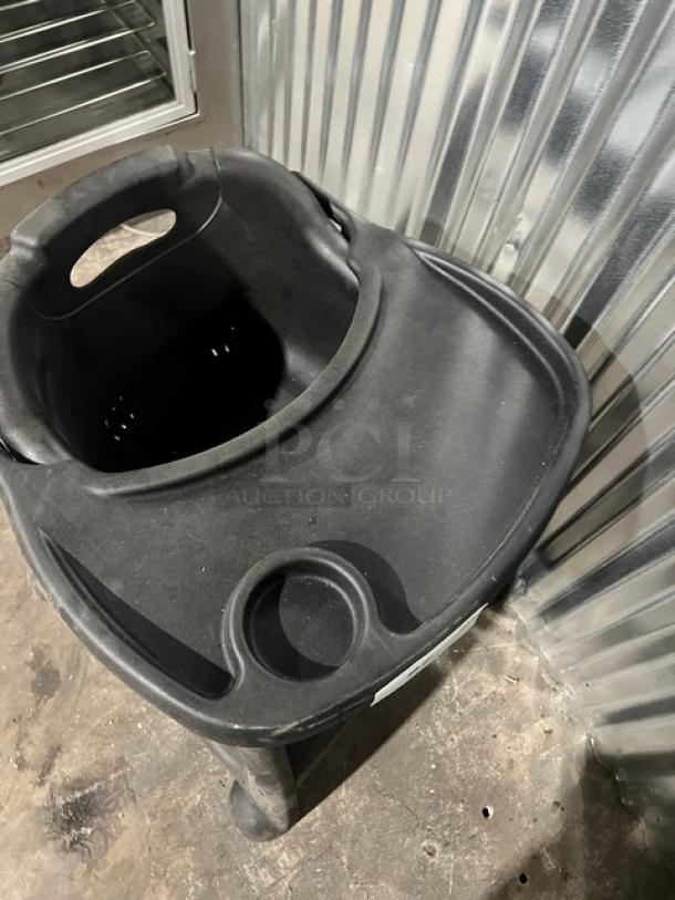 Commercial black high chair with tray, durable plastic, integrated cup holder, good condition, ideal for restaurants.