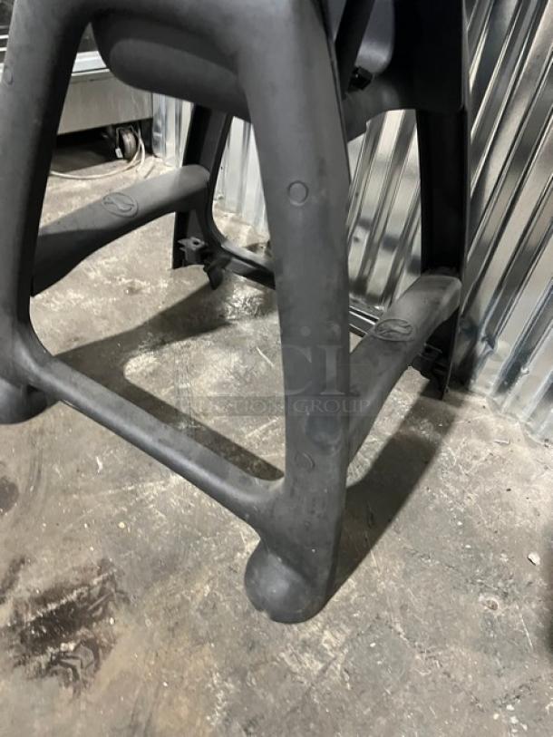 Commercial black restaurant high chair with tray, sturdy design, durable material, minor wear, suitable for heavy use.