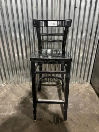 Black bar-height chair, commercial grade, wooden slatted back, used condition with visible wear. Label reads "96 X6."
