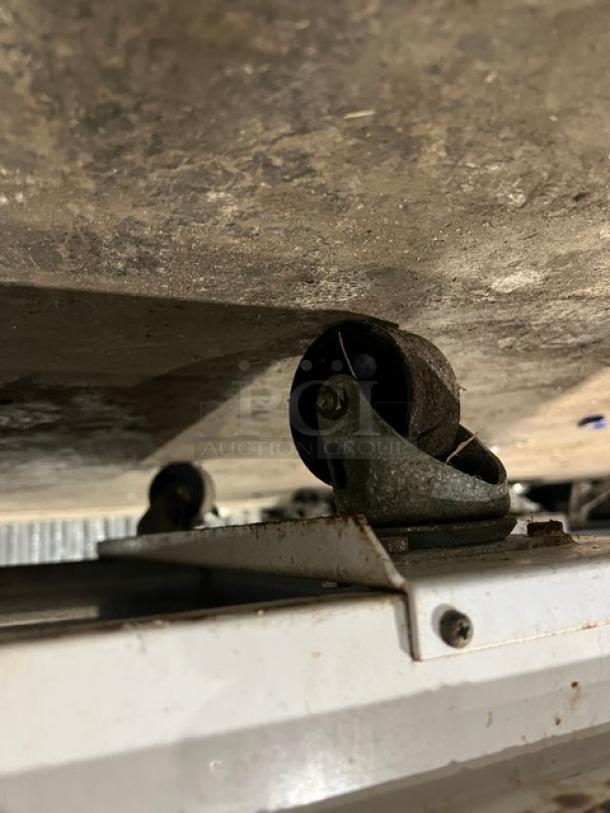 Kelvinator commercial ice cream dipping cabinet on casters, white finish, flip-top lid, shows casters for mobility.