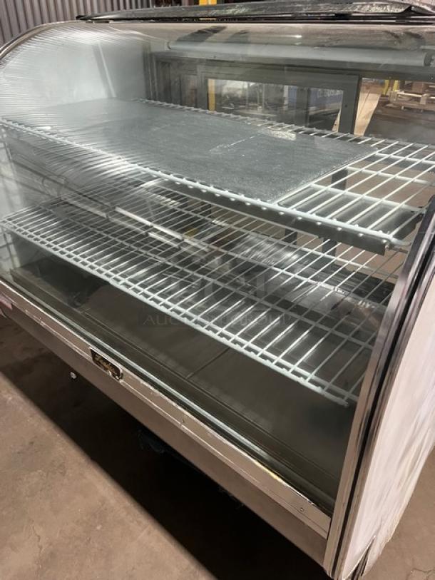 Leader commercial stainless steel curved glass refrigerated bakery display case with three tiers, rear sliding doors, poly coated wired racks, model 115V 1 Phase.