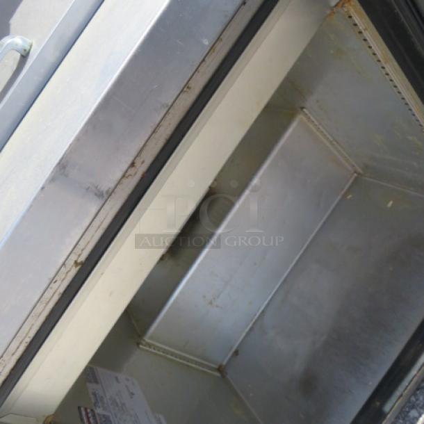 True TSSU-27-06-HC refrigerated prep table, one door, with two stainless steel shelves and 24-inch ticket rail, on casters.