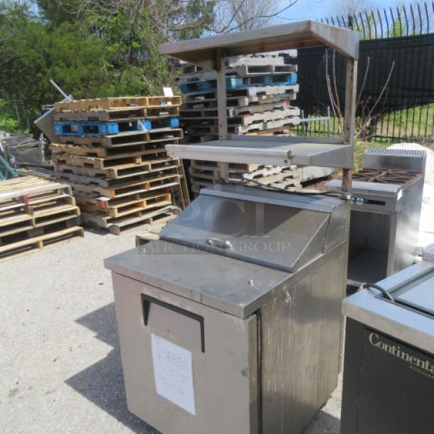 True TSSU-27-06-HC refrigerated prep table, 1 door, 2 shelves, 24" ticket rail, on casters, 27.5x31.5x67, 115V, good condition.