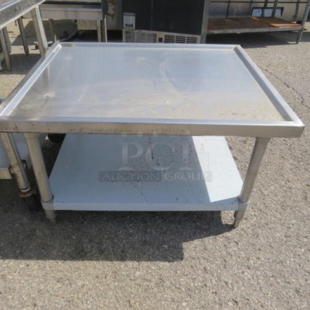 Stainless steel equipment table with undershelf, 36x30x21 inches. Good condition, ideal for kitchen use.