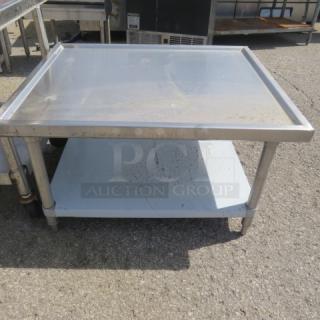 Stainless steel equipment table with undershelf, 36x30x21 inches. Good condition, ideal for kitchen use.