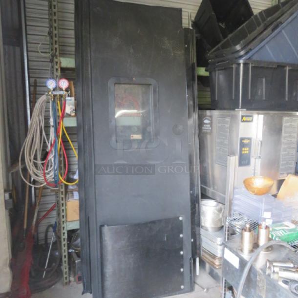 Black kitchen traffic door, 36x93 inches, features a central window, sturdy design, and scuff-resistant panel. Used condition.