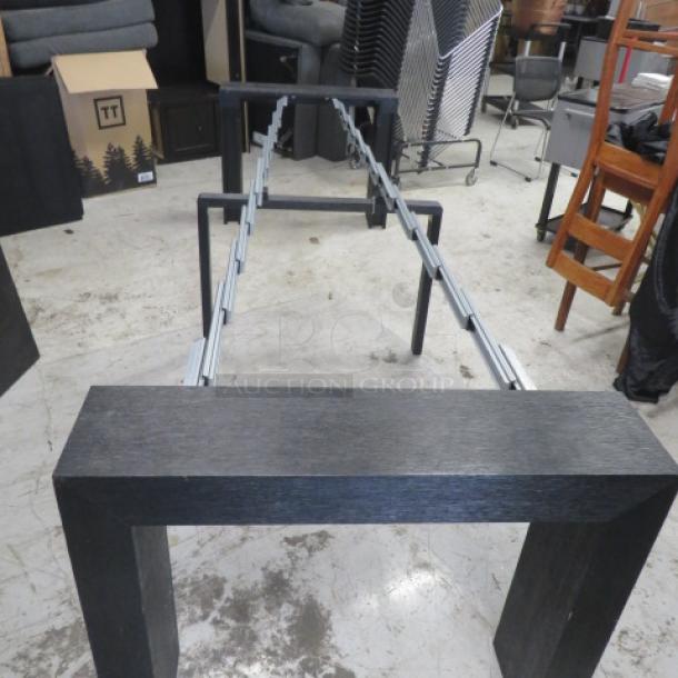 Adjustable table with two end pieces and four inserts. Can extend to 8 feet. Black finish. Dimensions: 98x37.5x30 inches.