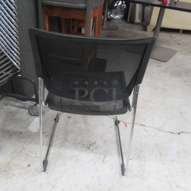 Stackable metal and black poly event chair, mesh back, chrome legs, modern design, used condition.