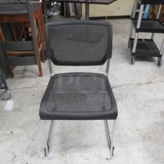 Stackable metal and black poly event chair with mesh back and seat, chrome legs; lightly used.