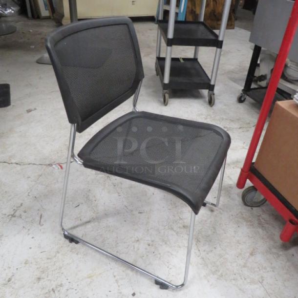 Stackable black poly and metal event chair in good condition, mesh back and seat, chrome frame. Suitable for office or events.