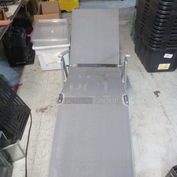 Foldable lounge chair, gray mesh fabric, metal frame, good condition, adjustable back, suitable for outdoor use.