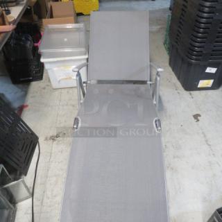 Foldable lounge chair, gray mesh fabric, metal frame, good condition, adjustable back, suitable for outdoor use.