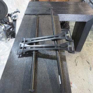 Black A/V mount poles, metal construction, good condition, dual stabilizing brackets, ideal for audio/video setups.