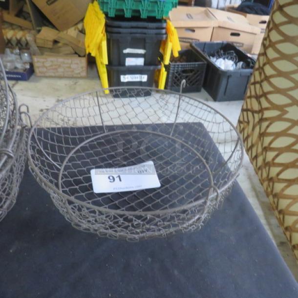 11-inch round wire basket, metal construction, used condition. Auction tag labeled "Lot 91." 6XBID model.