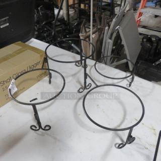 Black metal buffet holder with four circular tiers. Features elegant scroll legs. Slight wear visible. ID tag attached.