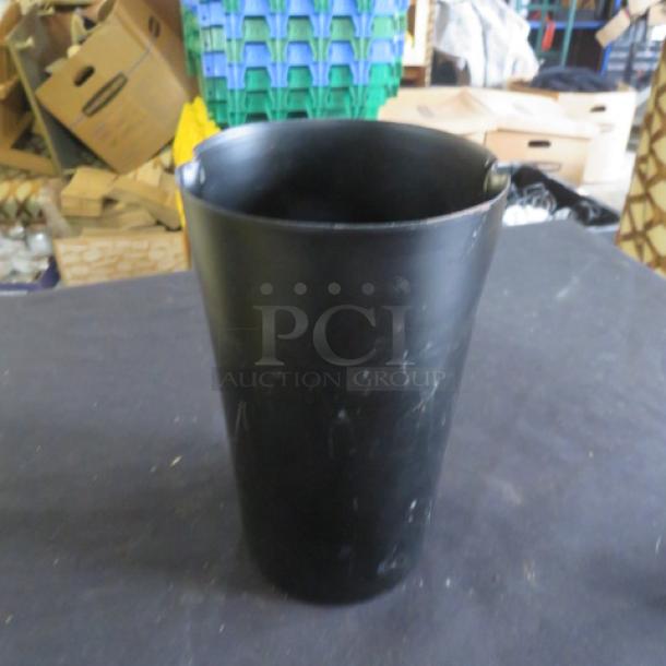 Black metal holder, cylindrical, 5x8 inches. Smooth finish, slightly worn. Ideal for organizing tools or utensils.