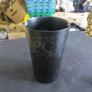 Black metal holder, cylindrical, 5x8 inches. Smooth finish, slightly worn. Ideal for organizing tools or utensils.