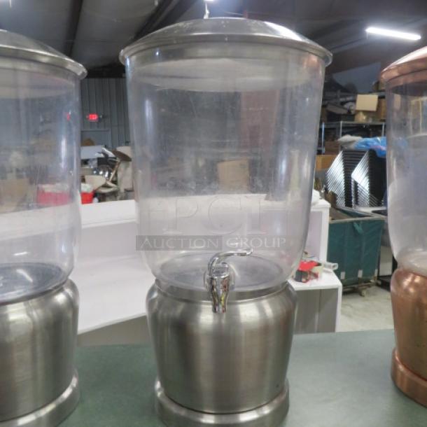 Stainless steel and poly beverage dispenser with spigot, clear polycarbonate top, and brushed metal base, in good condition.