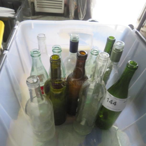 Assorted glass vases in a plastic bin, varying in size and color, some with tags or markings, indicating a bulk auction lot.