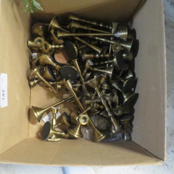 Assorted brass candlesticks in a cardboard box, various sizes and styles, in good condition. Auction lot number 142 visible.