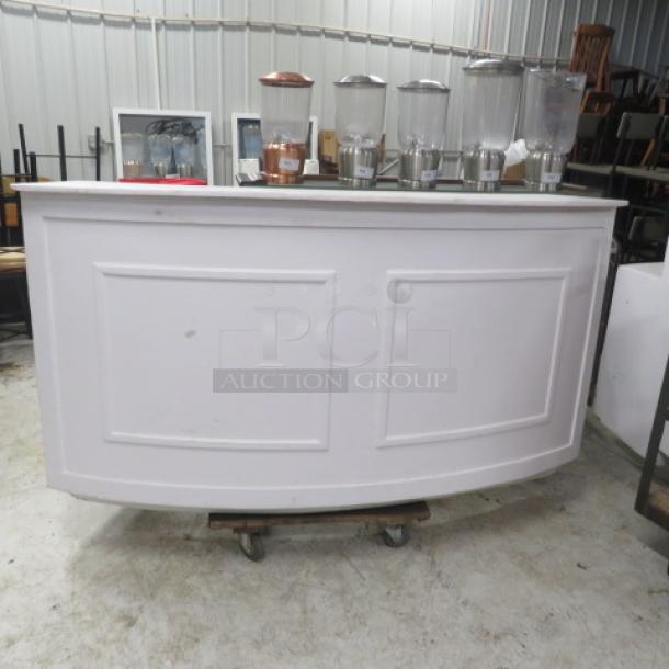 One white wooden curved portable bar with under storage. Dimensions: 77x30x42 inches. Includes panel detailing.