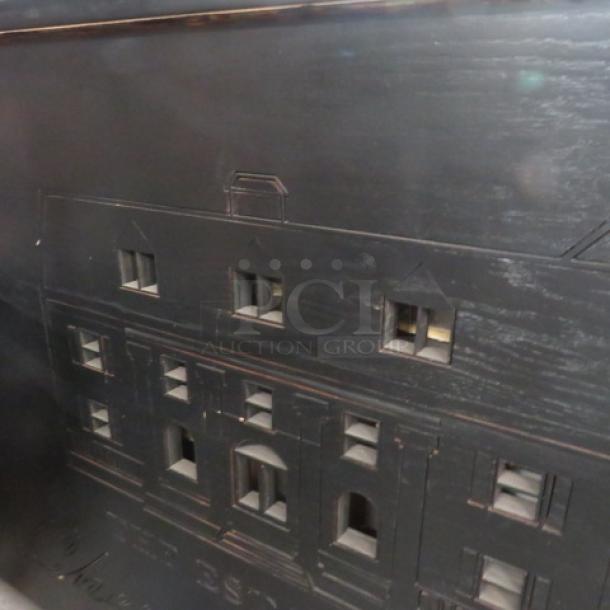 Portable bar with black laminate serving shelf, two stainless steel ice wells, three bottle rails, and casters, 95x31x46.