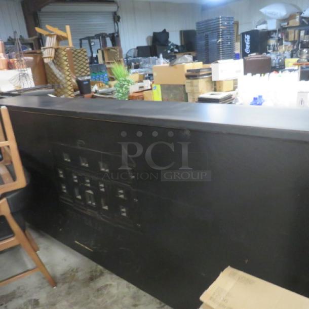 Portable bar with 2 stainless steel ice wells, black laminate serving shelf, bottle rails, and under storage. 95x31x46 inches.