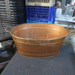 Copper color beverage holder, 21x15x9 inches, oval shape with side handles, minor wear, suitable for storage or display.
