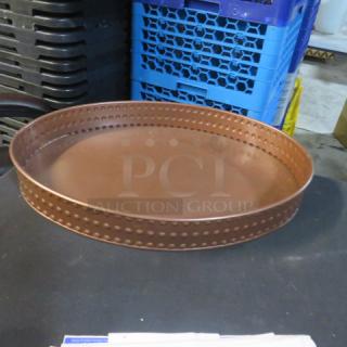 Hammered copper color oval serve tray, 16x11x2 inches, with dot pattern on rim. Item code 4XBID.