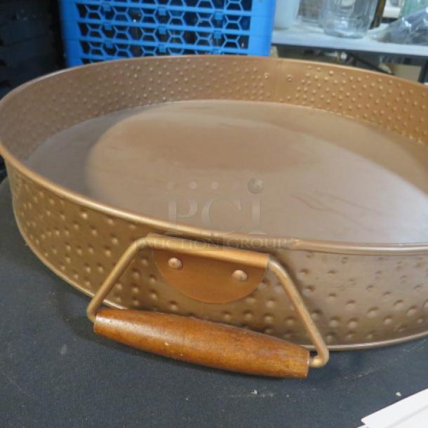 Copper-colored hammered round serve tray, 16.5x2.5 inches, features wooden handles, excellent condition.