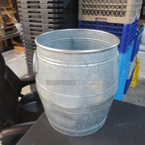 Galvanized 16-inch barrel in excellent condition, featuring a ribbed design for durability, ideal for storage or decoration.