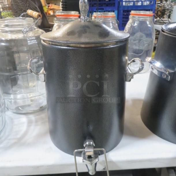 Black beverage dispenser with lid and handles, stainless steel tap, textured finish, in excellent condition.
