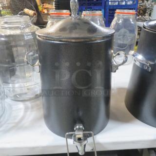 Black beverage dispenser with lid and handles, stainless steel tap, textured finish, in excellent condition.