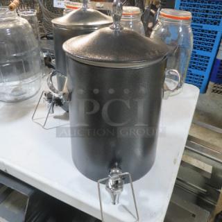 Black beverage dispenser with lid and chrome spigot, metal handles, in good condition.