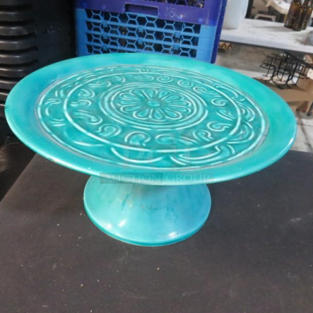 Turquoise ceramic cake stand, 12-inch, ornate floral pattern on top, gently used condition.