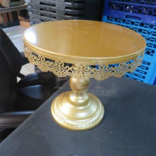 Elegant 10-inch gold cake stand with ornate lace trim design, excellent condition, ideal for events and display.