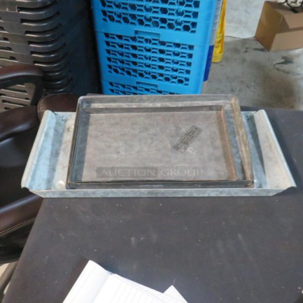 Assorted galvanized serve tray, rectangular shape, with raised edges and rustic finish. Used condition on display table.