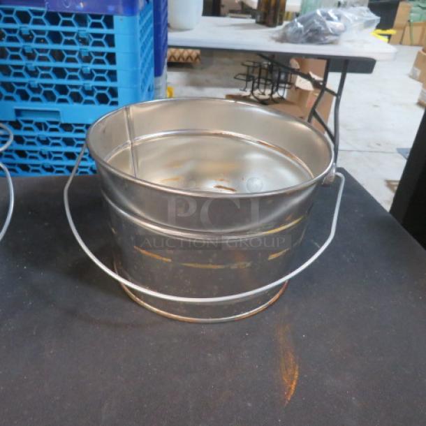 Tin bucket, 7x5 inches, in used condition with handle and some rust spots. Sturdy build, suitable for various uses.