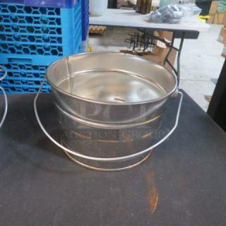 Tin bucket, 7x5 inches, in used condition with handle and some rust spots. Sturdy build, suitable for various uses.